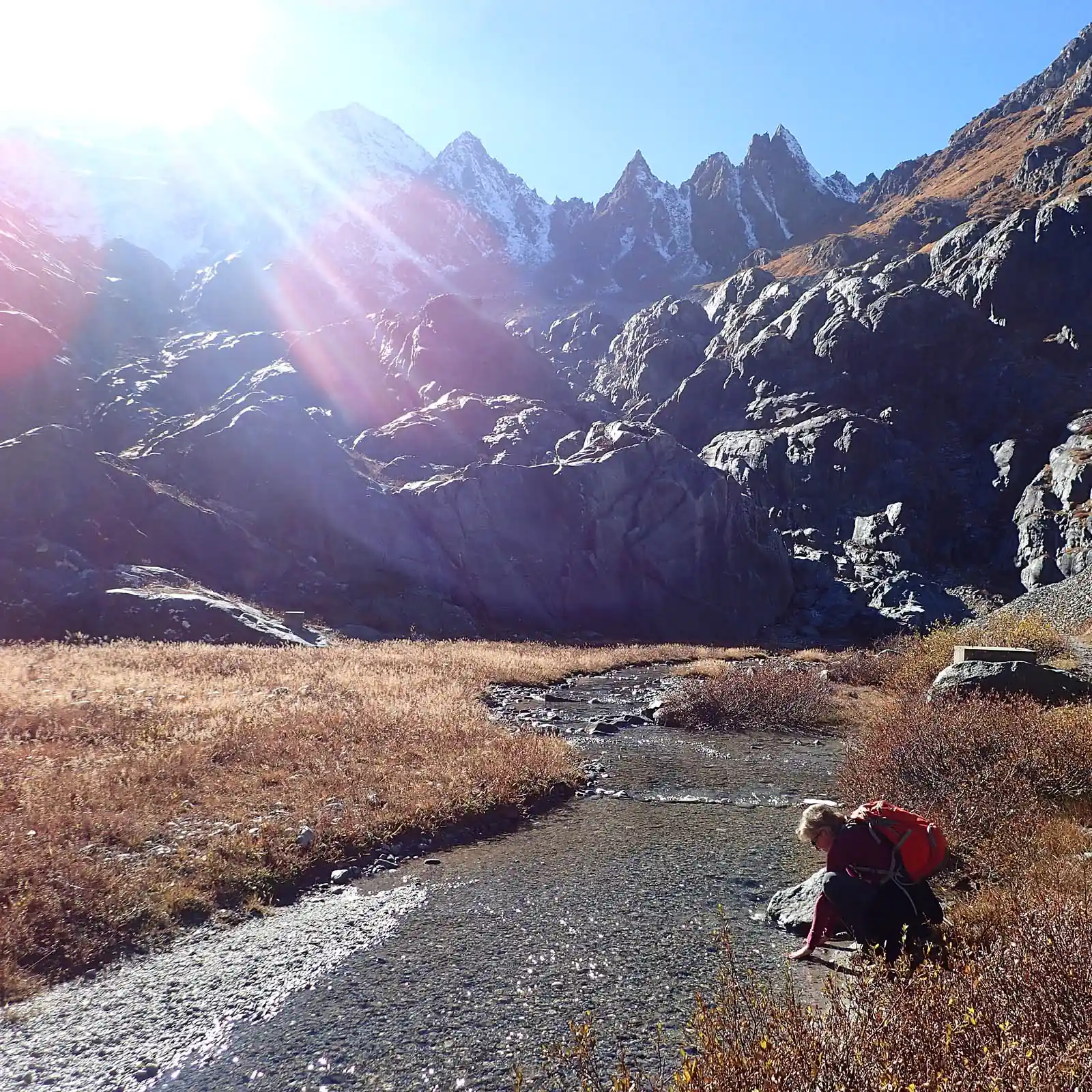 Photo d'une randonneuse au bord d'un torrent entre Verbier et Zermatt